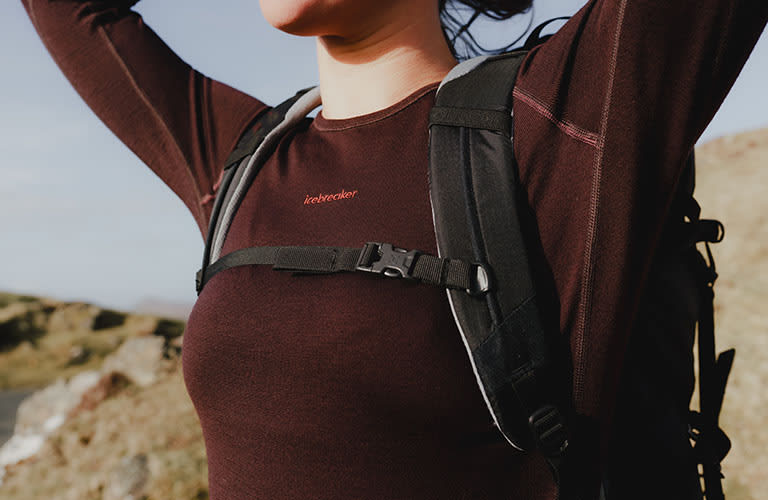Woman hiking wearing an icebreaker zoneknit merino base layer thermal top