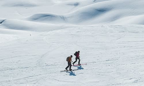 Two people nordic skiing wearing icebreaker merino jackets
