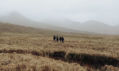 Four people backpacking wearing icebreaker merino wool jackets and merino sweatshirts