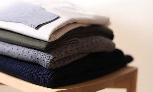 Pile of folder icebreaker merino sweaters and merino base layers
