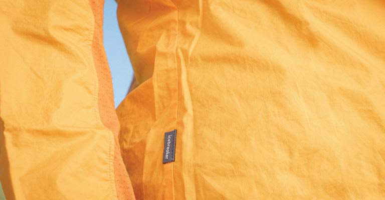 Close up of orange icebreaker Shell+ merino windbreaker jacket