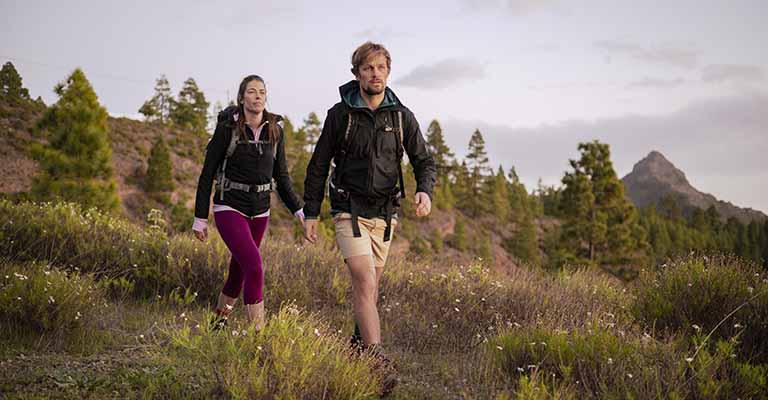 Man and woman hiking wearing icebreaker Shell+ windbreaker jackets