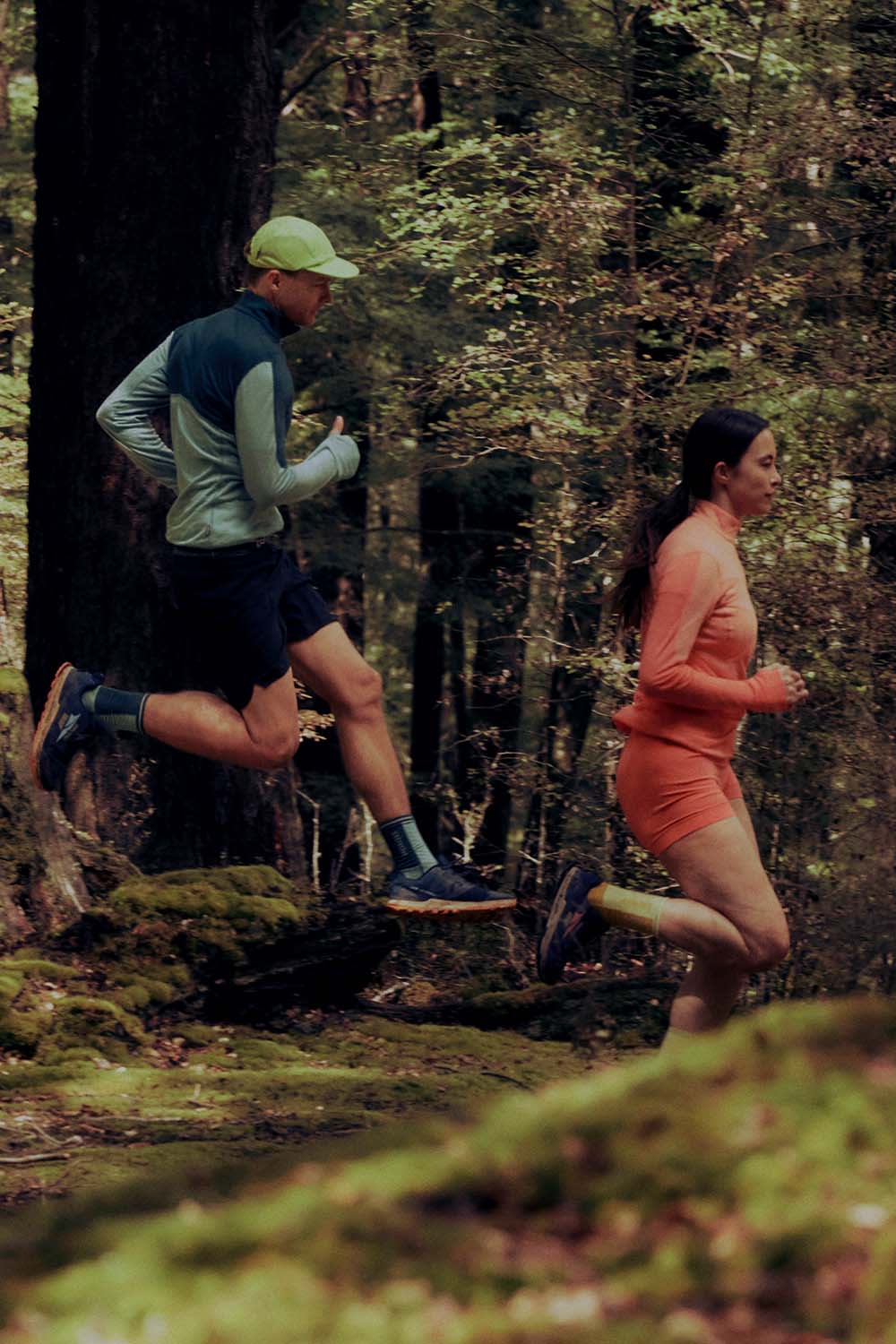 Three people running in a forest wearing icebreaker merino long sleeve tops and merino shorts