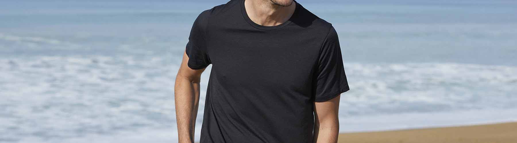 Man standing on the beach wearing black icebreaker merino t-shirt