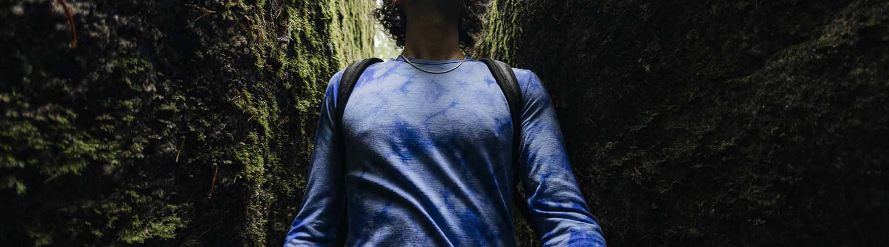 Man hiking wearing blue icebreaker merino base layer thermal top