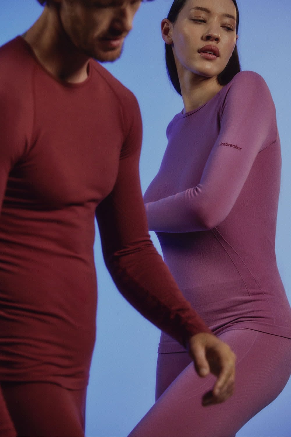 Man and woman wearing icebreaker seamless merino base layer thermal tops and merino leggings