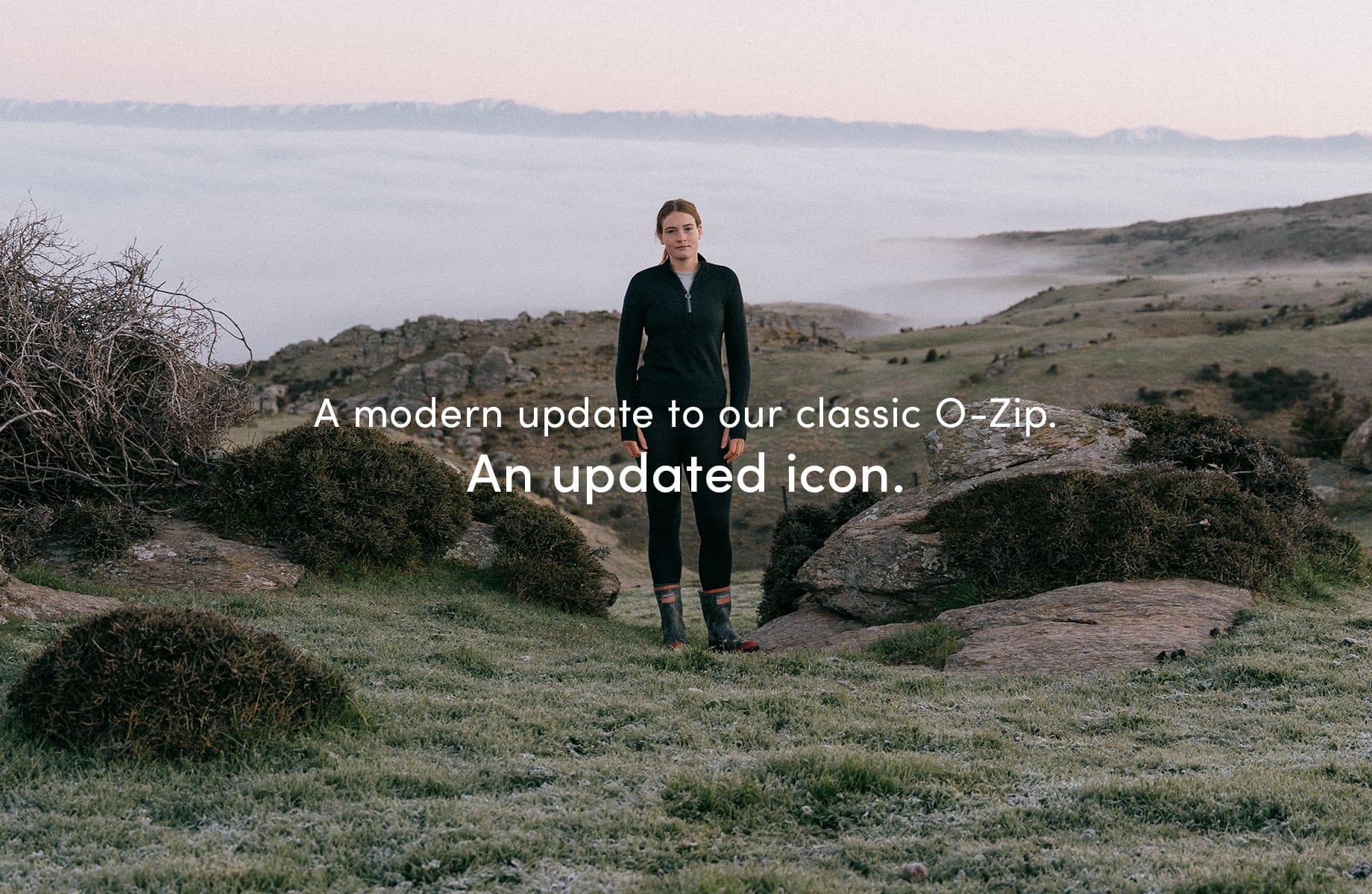 A girl standing outside in nature on a mountain, there are clouds below her. She is wearing the icebreaker o zip mid layer. There is text on the image that reads "a modern update to our classic o-zip. An updated icon."

Click on image to discover more.