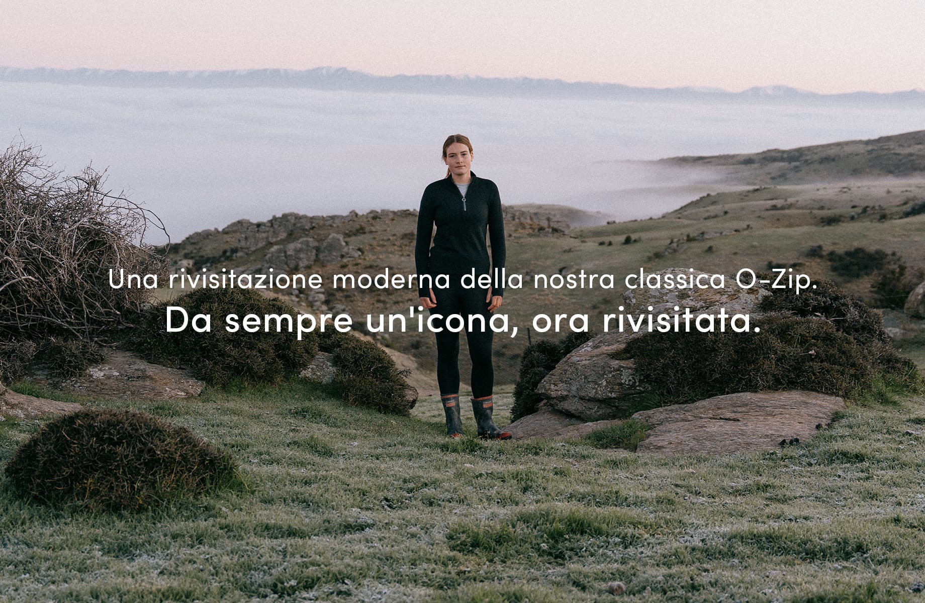 A girl standing outside in nature on a mountain, there are clouds below her. She is wearing the icebreaker o zip mid layer. There is text on the image that reads "a modern update to our classic o-zip. An updated icon."

Click on image to discover more.