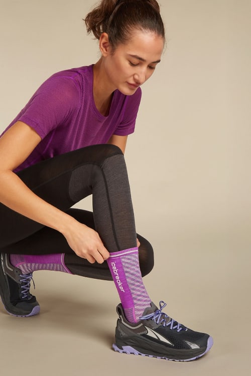 Woman pulling up icebreaker merino running socks