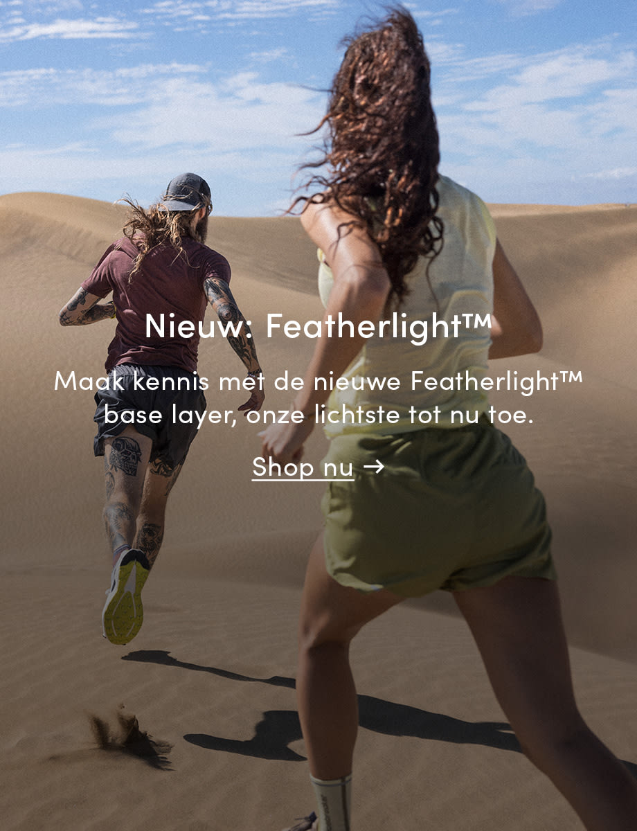 Two people running in icebreaker featherlight in the sand. The text on the image reads: New: Featherlight. Introducing the new Featherlight base layer, our lightest yet. Click on the image to shop now.