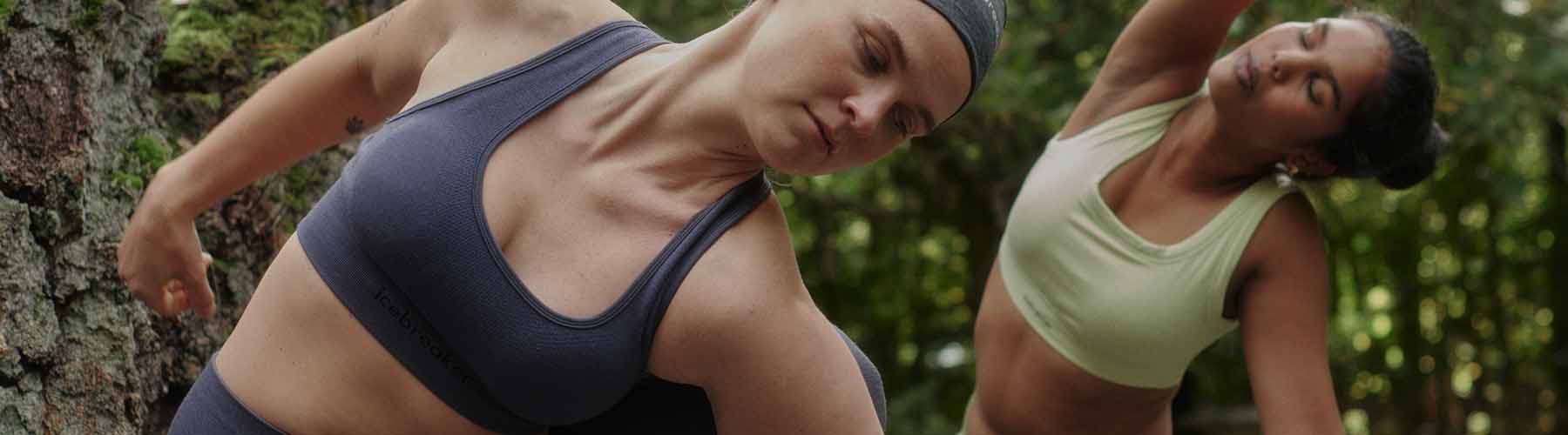 Deux femmes pratiquant le yoga portant des soutiens-gorge sans coutures Icebreaker.