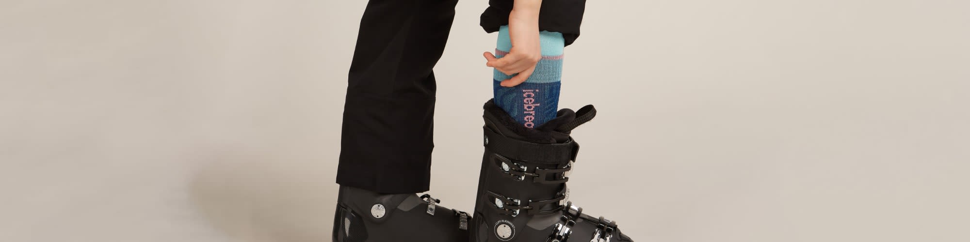 Personne en train de remonter une chaussette de ski en mérinos Icebreaker