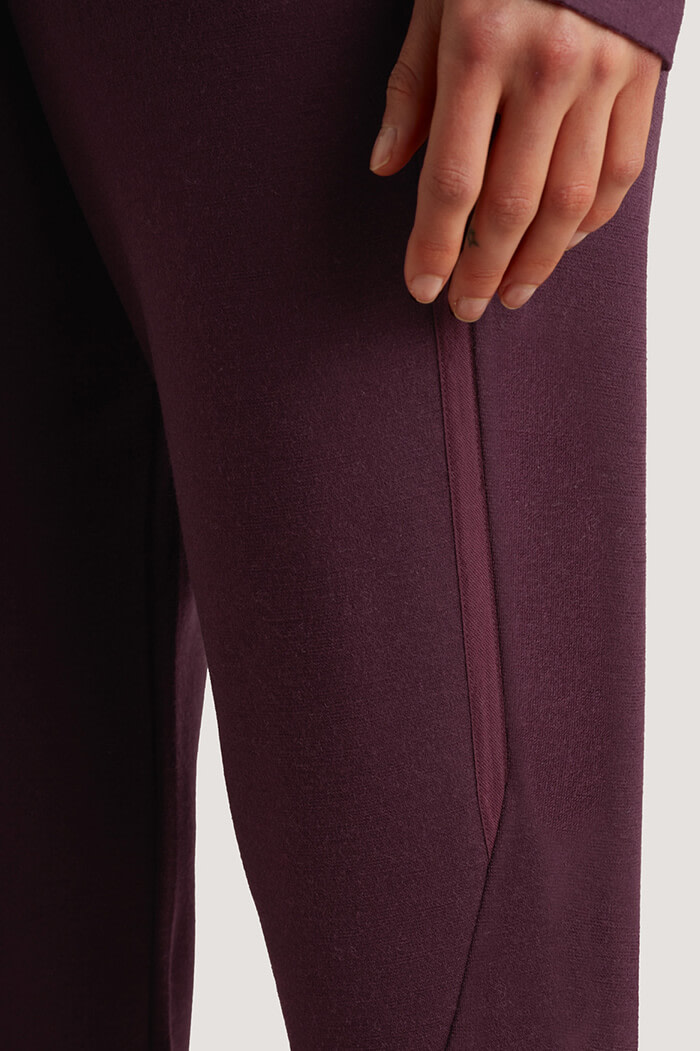 Closeup shot of a leg in purple trousers.