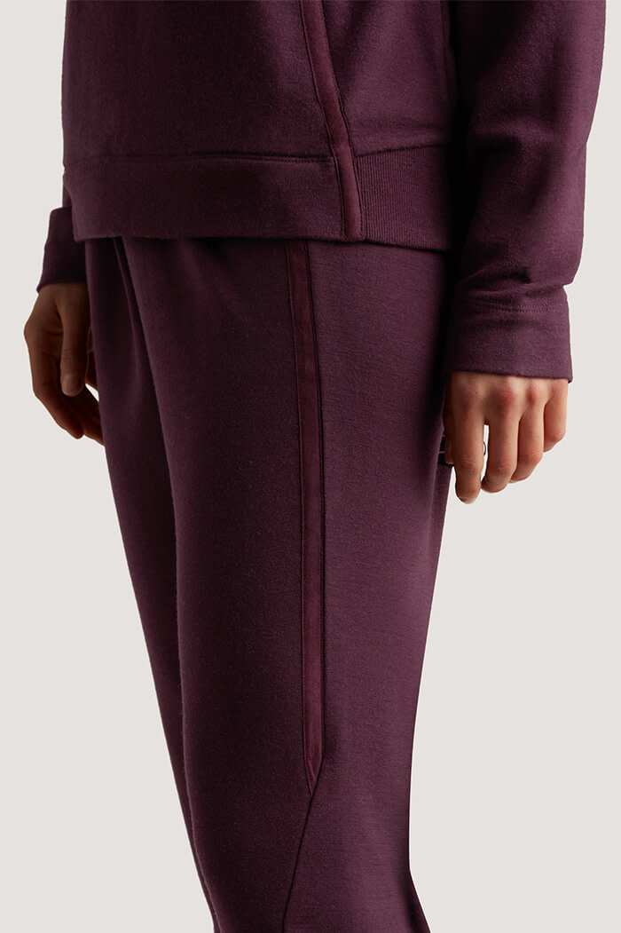 Close up of woman in merino purple trousers.