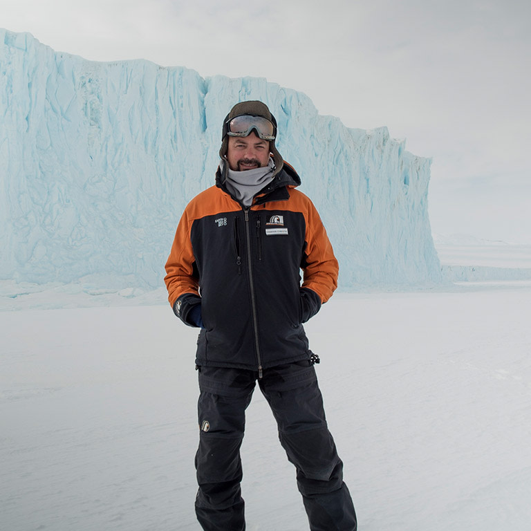 Antarctica scientist standing near ice-shelf