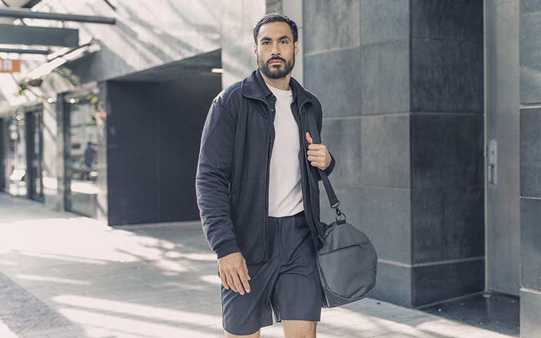 Man walking in the street carrying a duffle bag