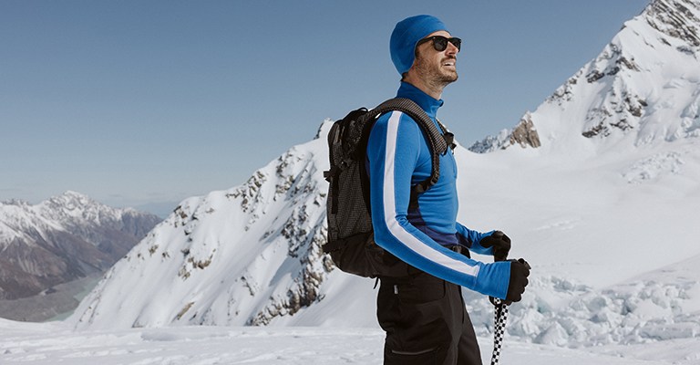 Man skiing wearing a blue icebreaker zoneknit base layer merino thermal top
