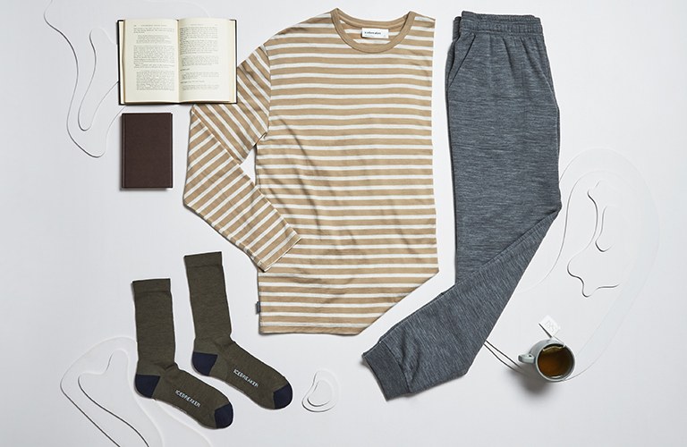 icebreaker long sleeve top, joggers and socks lying on the ground next to an open book