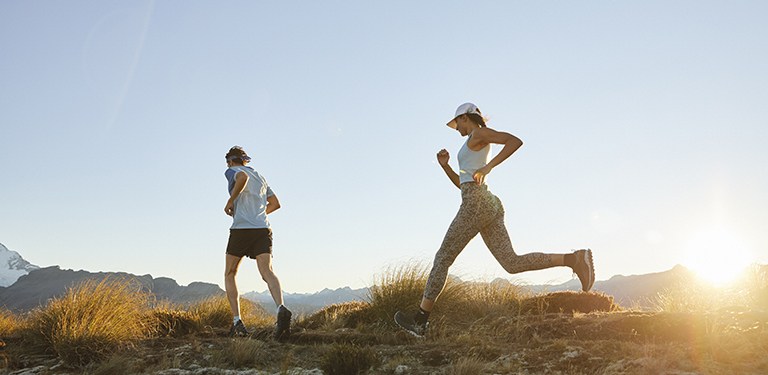 Man and woman trail running at sunrise