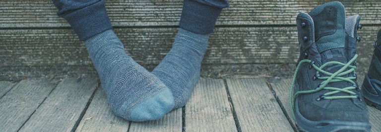 Personne assise portant des chaussettes de randonnée icebreaker mérinos