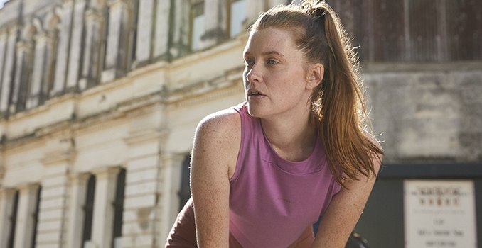 Woman running wearing a pink icebreaker merino zoneknit tank