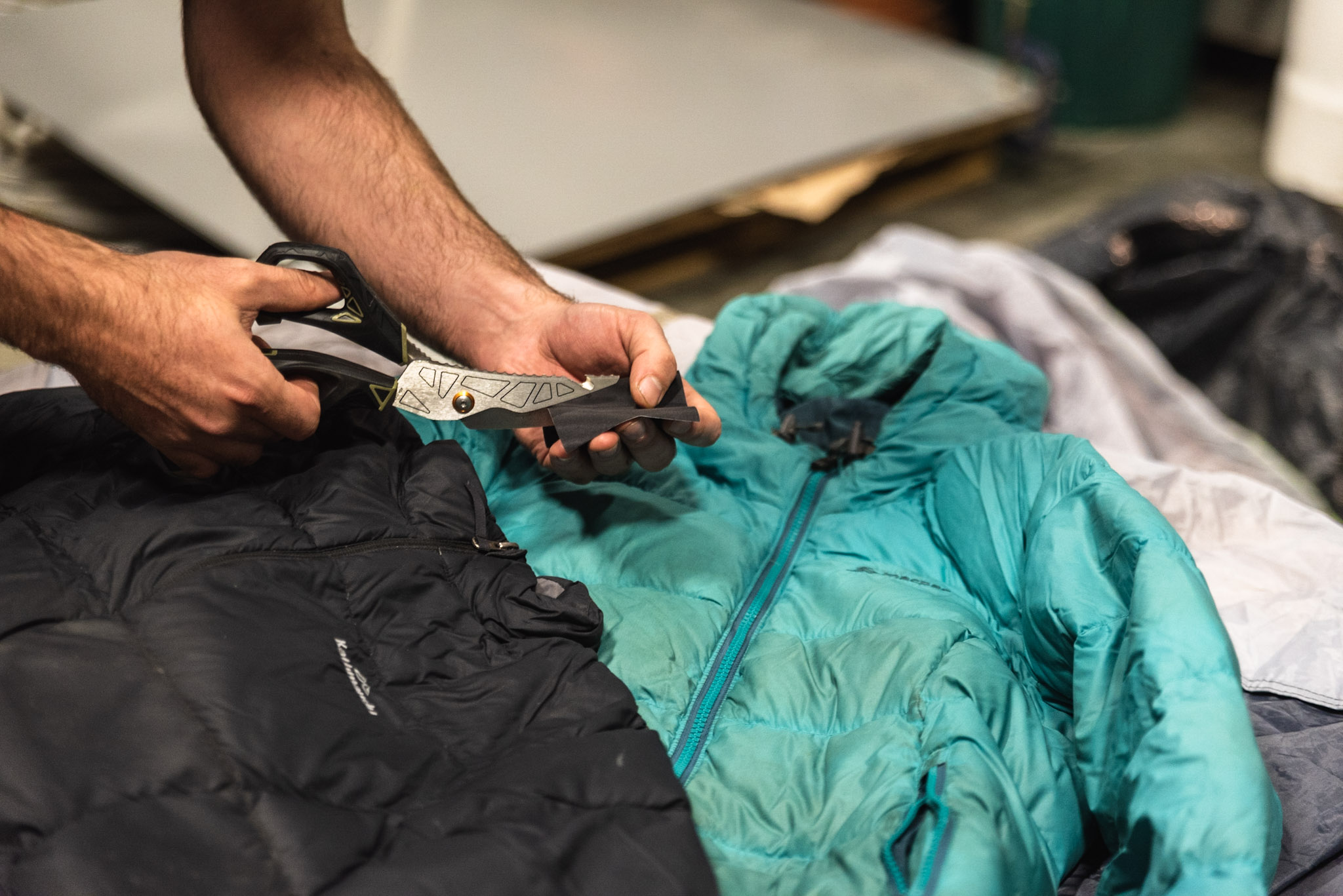 cutting a patch of fabric to repair a jacket to reuse.