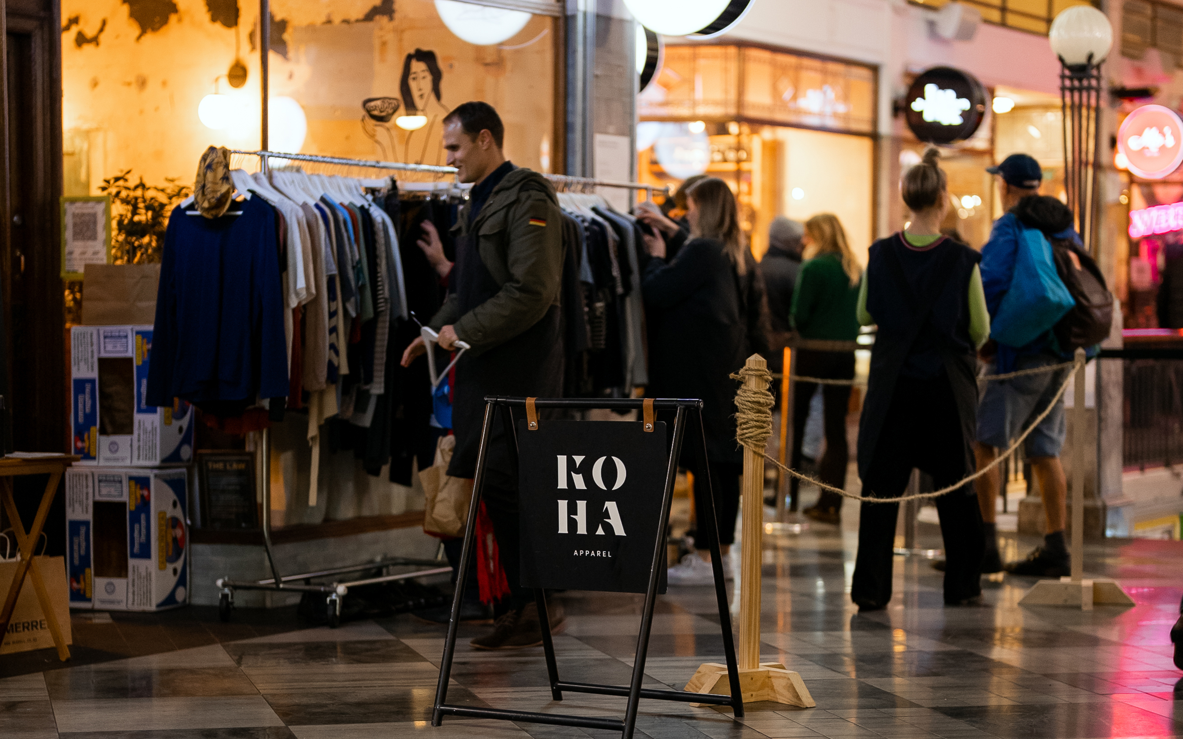 People shopping racks at Koha stall