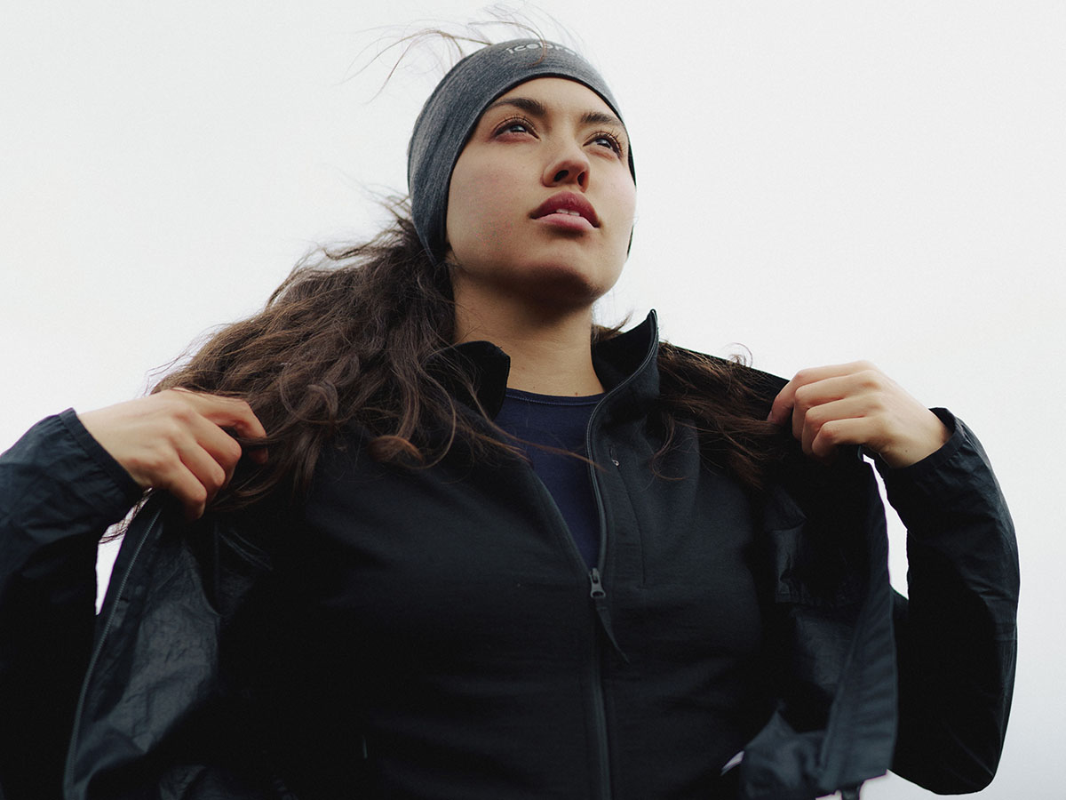 Femme portant une veste en mérinos icebreaker par-dessus un sweat à capuche et un haut thermique en mérinos