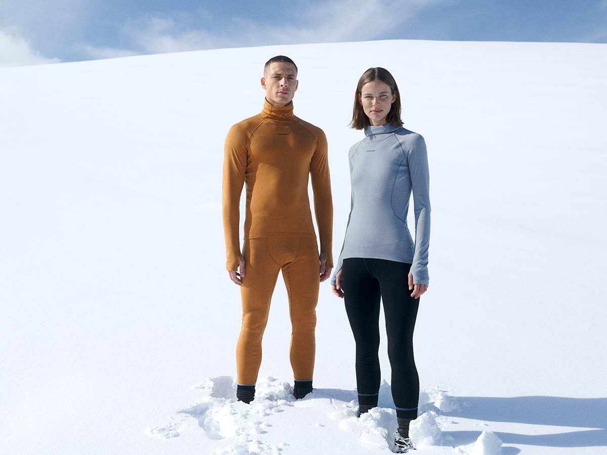 Un homme et une femme debout dans la neige portant des sous-vêtements en mérinos brise-glace