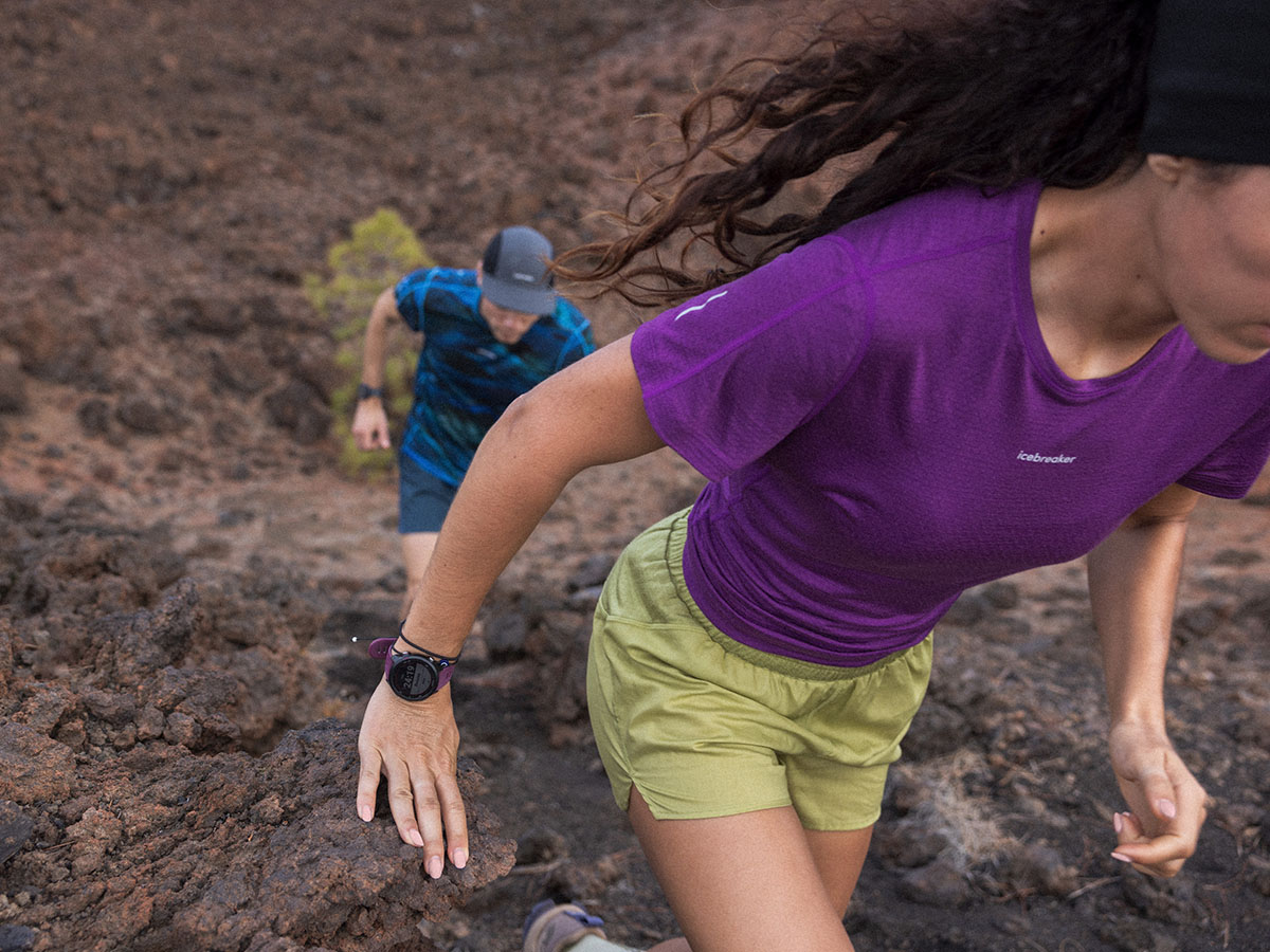 Une femme et un homme courant sur un sentier portant des t-shirts Icebreaker Cool-Lite Sphère