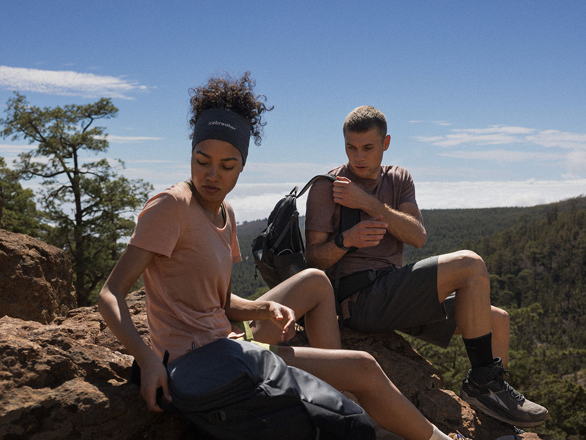 Un homme et une femme en randonnée portant des t-shirts Icebreaker Sphère