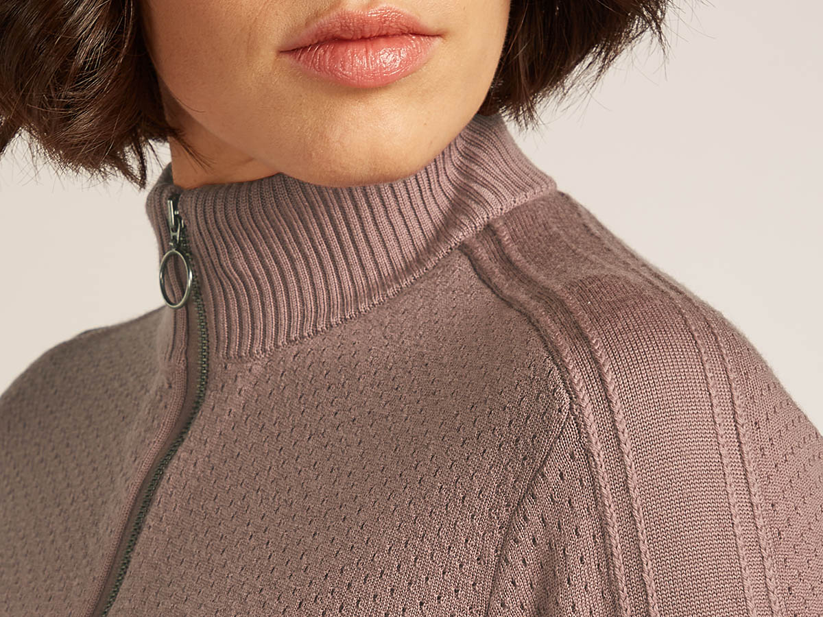 Woman wearing an icebreaker half zip merino sweater