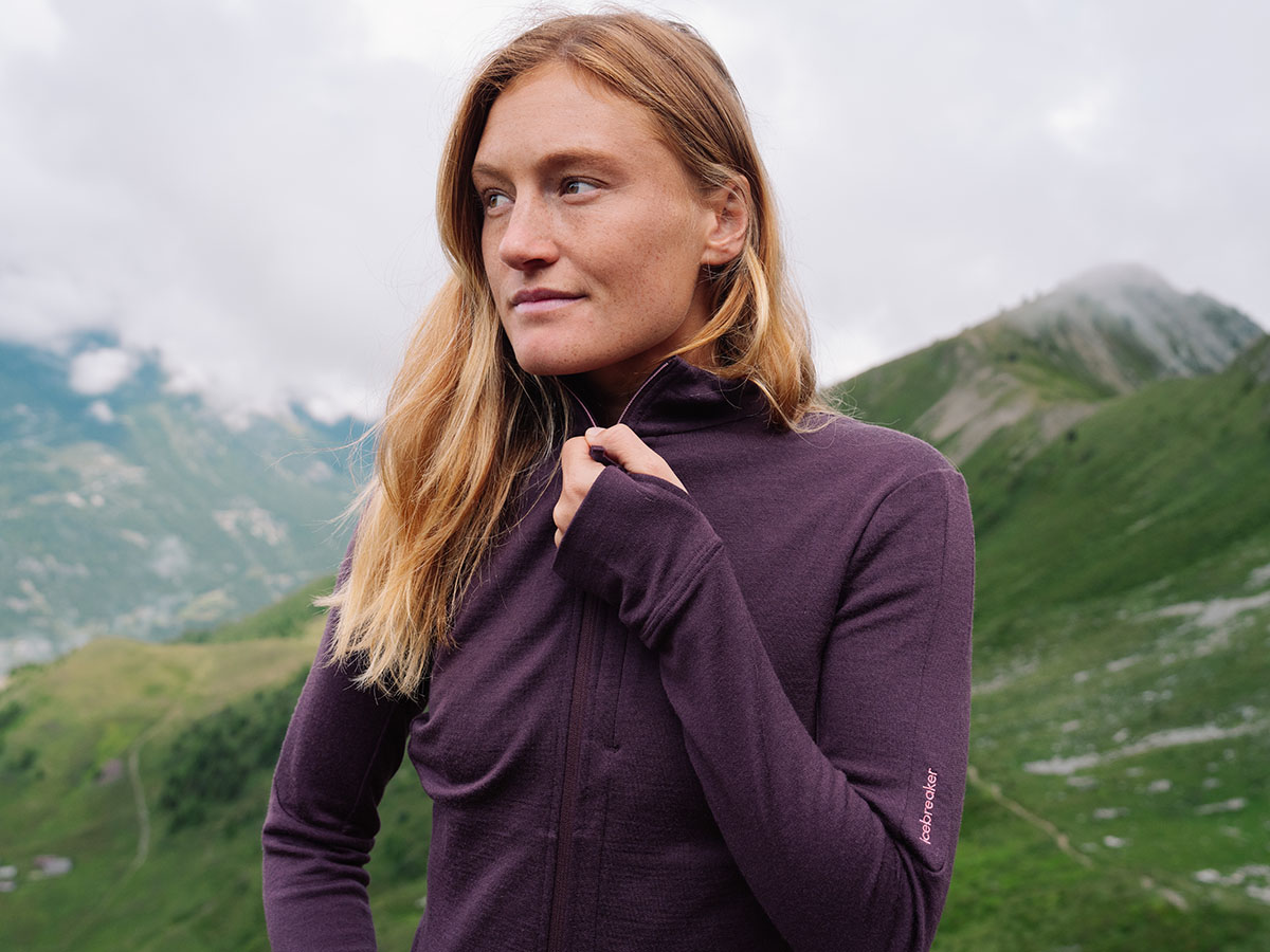 Femme en randonnée portant un sweat à capuche en laine mérinos